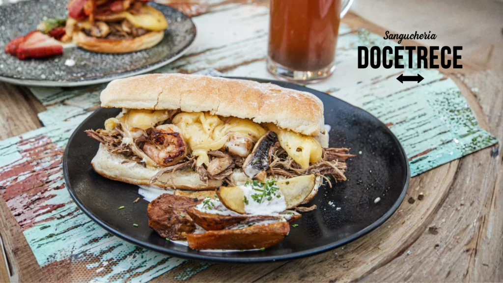 Sándwich gourmet de Sanguchería DoceTrece en Chile con carne mechada, mariscos y queso derretido, servido con papas rústicas y cerveza artesanal