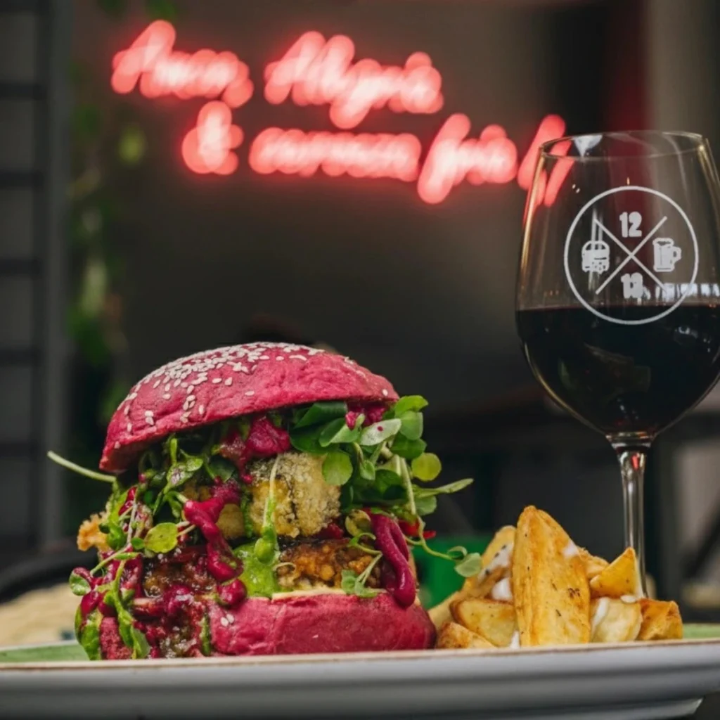 Hamburguesa gourmet en pan rosado con papas rústicas y copa de vino en Sanguchería DoceTrece en Chile, experiencia para maridar comida y vino